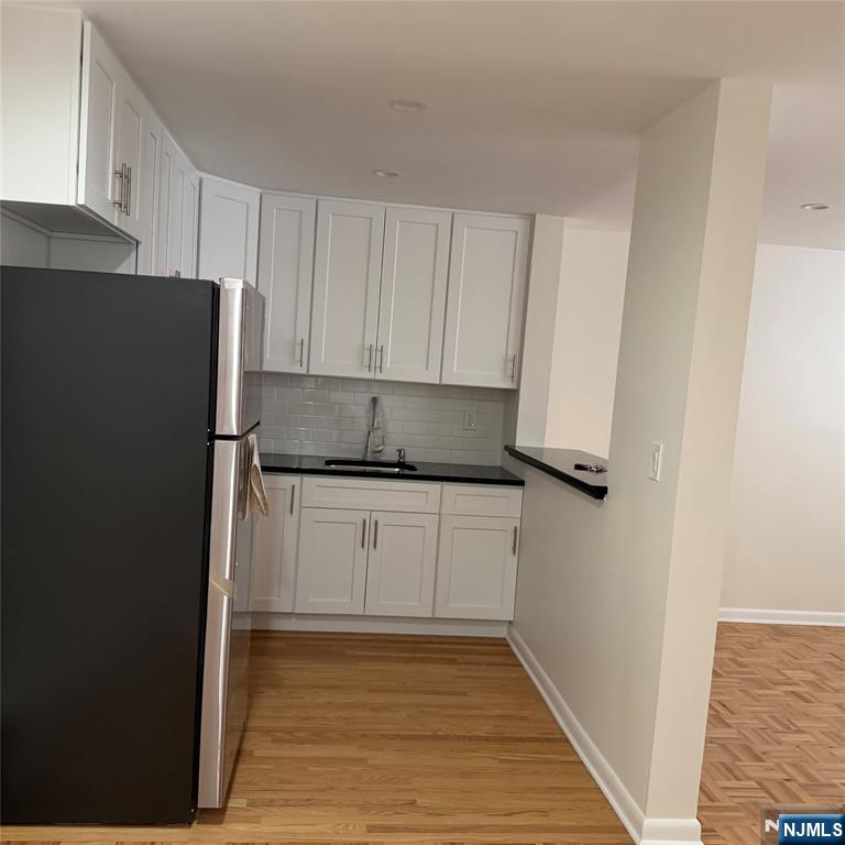 89 Uhland Street, Unit 8 East Rutherford, NJ 07073 - Photo 2 of 6 a kitchen with a refrigerator and cabinets