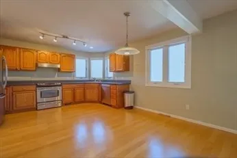 a kitchen with stainless steel appliances granite countertop a stove a sink and a refrigerator