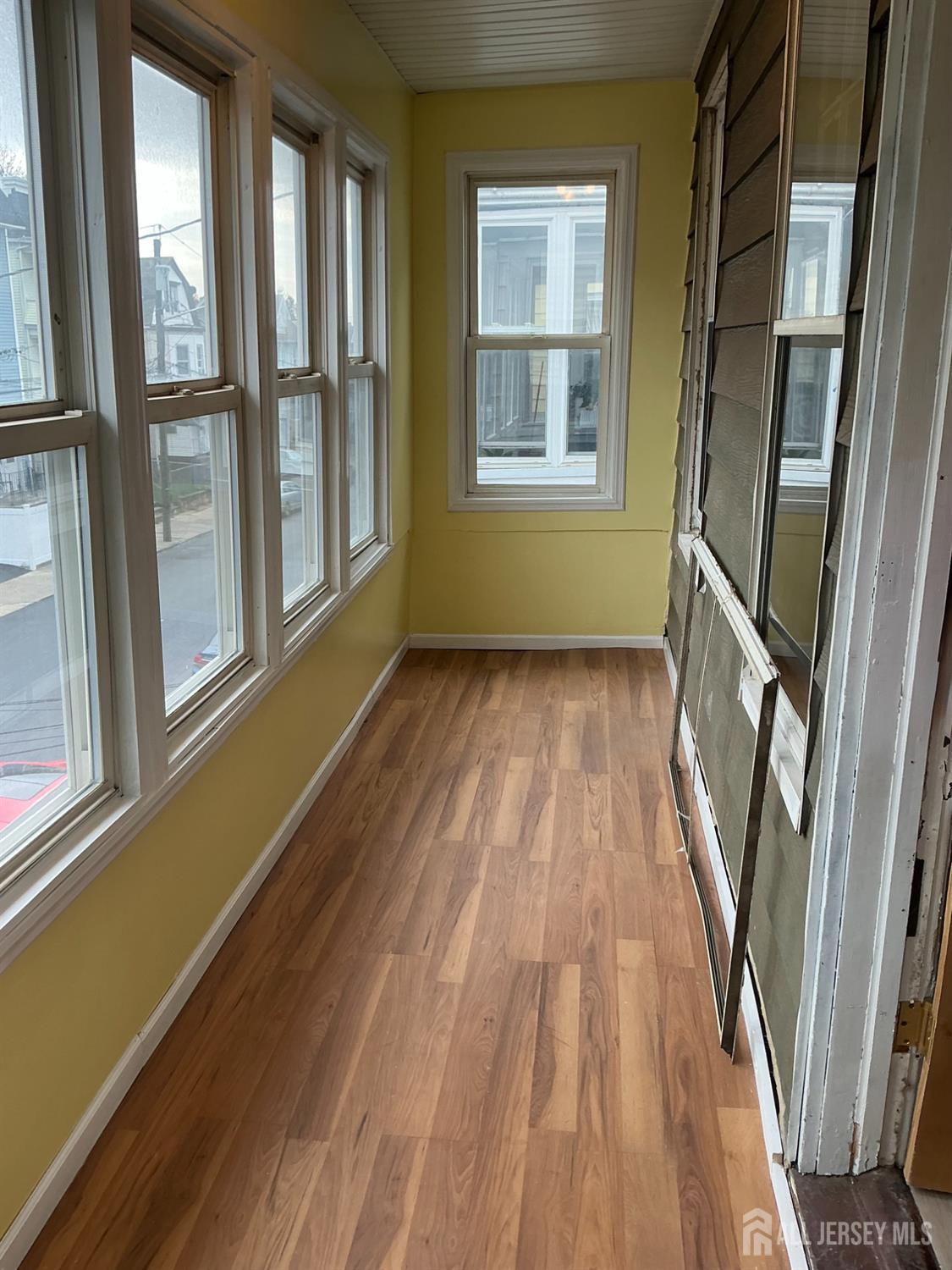 93 Schley Street, Unit 2 Newark, NJ 07112 - Photo 3 of 12 a view of an empty room with wooden floor and a window