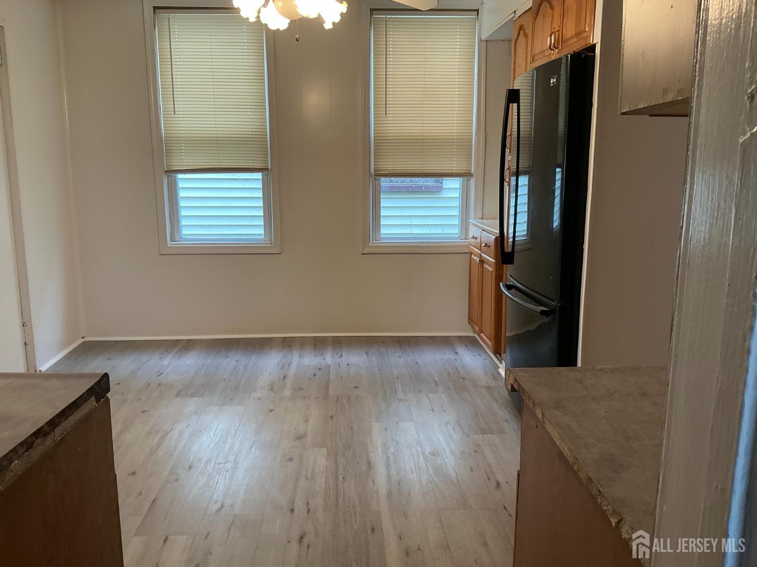 93 Schley Street, Unit 2 Newark, NJ 07112 - Photo 4 of 12 an empty room with wooden floor and a window