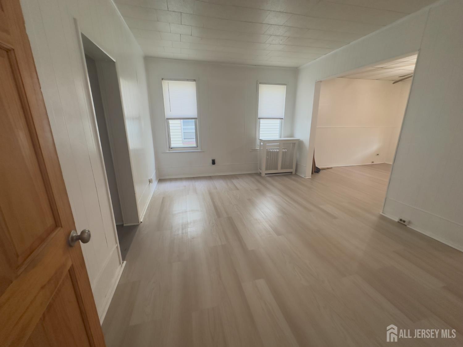 93 Schley Street, Unit 2 Newark, NJ 07112 - Photo 6 of 12 an empty room with wooden floor and windows