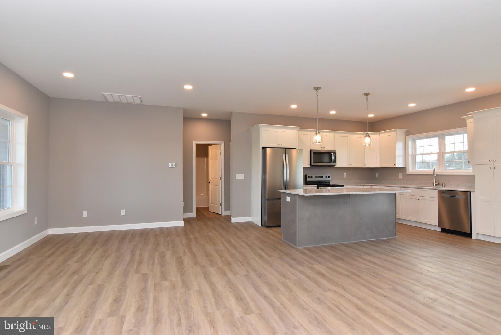 36078 Columbia Road Delmar, DE 19940 - Photo 4 of 20 a large kitchen with stainless steel appliances a large counter top a refrigerator a sink and a stove