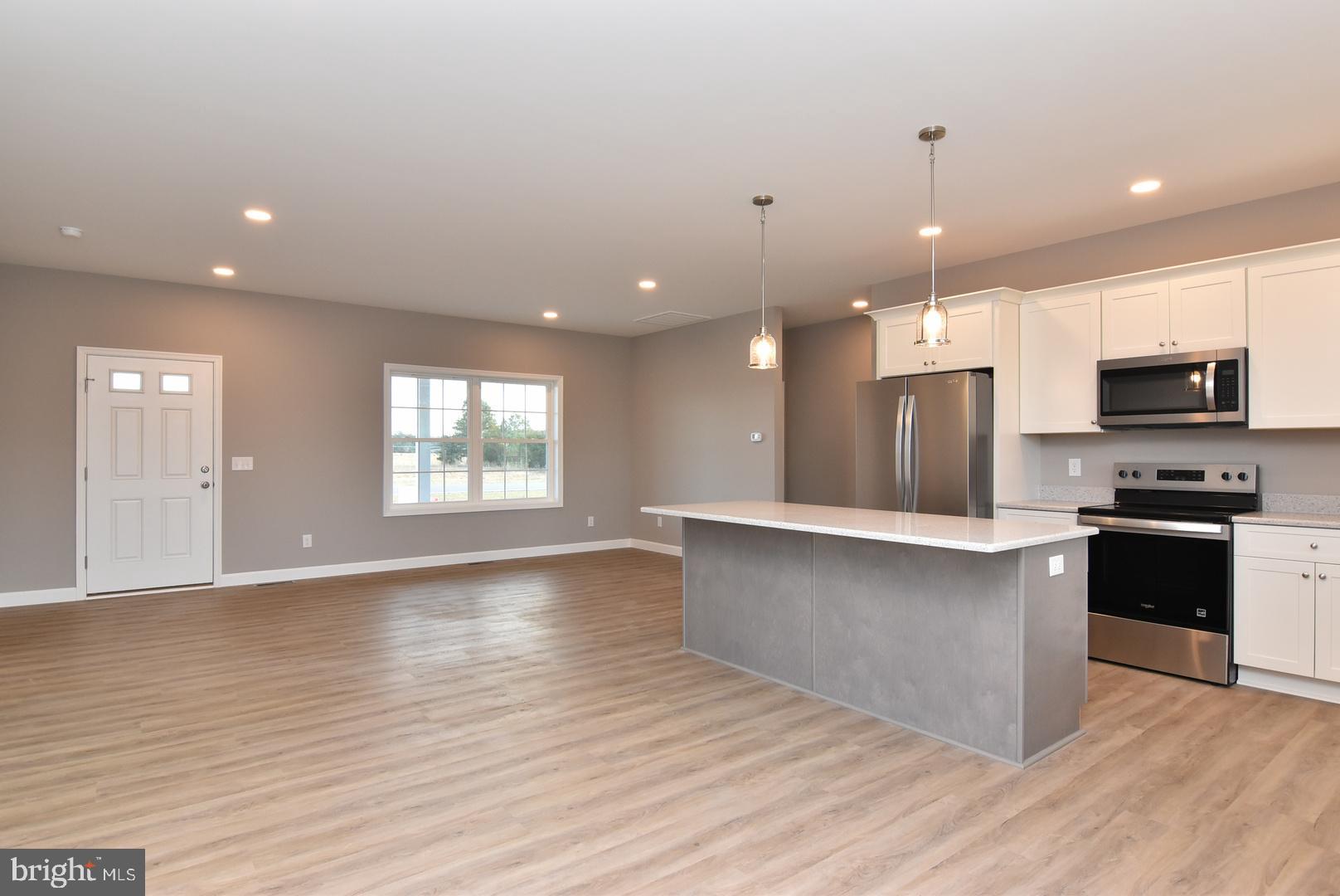 36078 Columbia Road Delmar, DE 19940 - Photo 5 of 20 a large kitchen with stainless steel appliances a large counter top a sink a refrigerator and a window