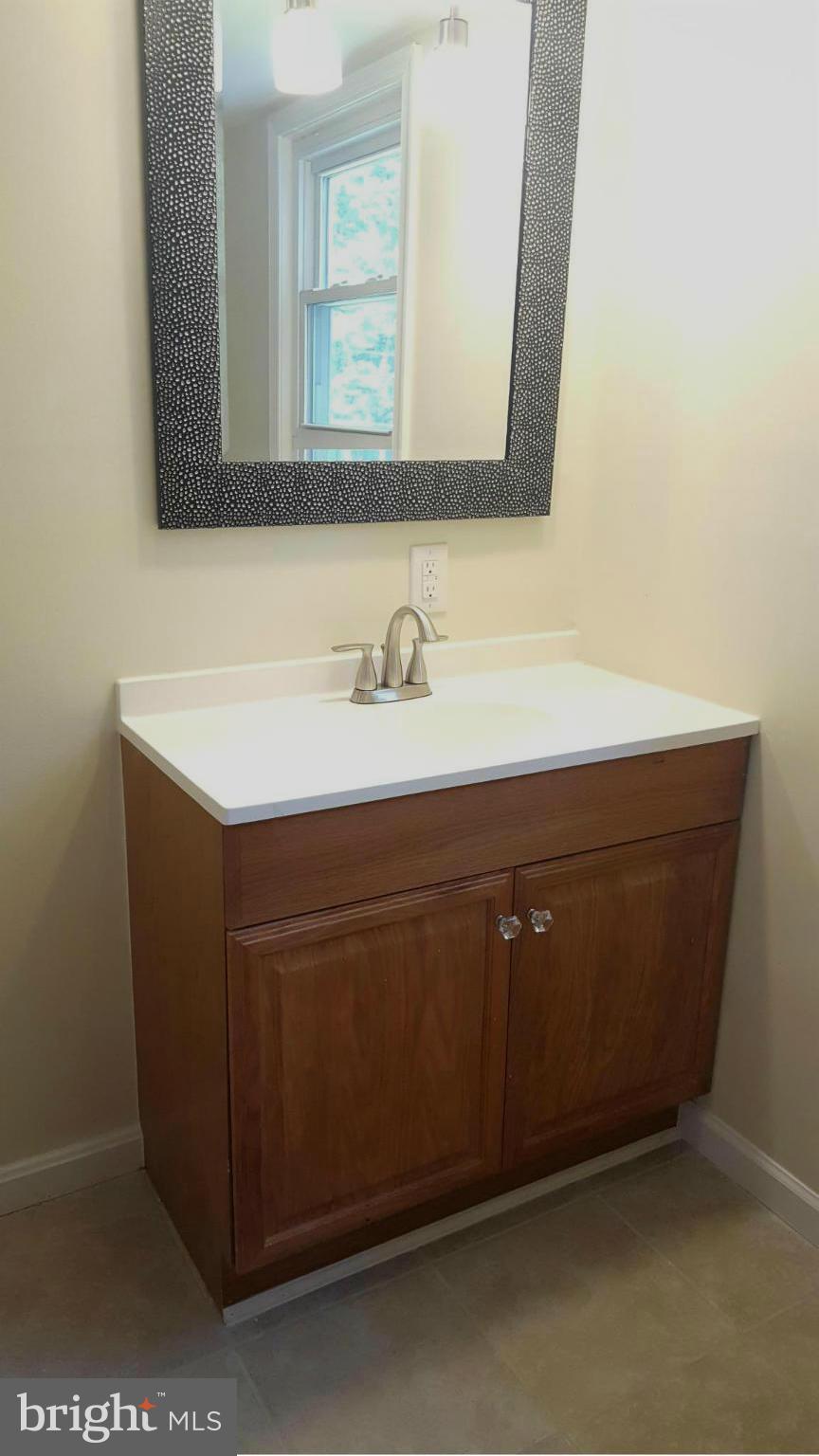 6009 Poplar Road St. Leonard, MD 20685 - Photo 20 of 26 a bathroom with a sink vanity and a mirror