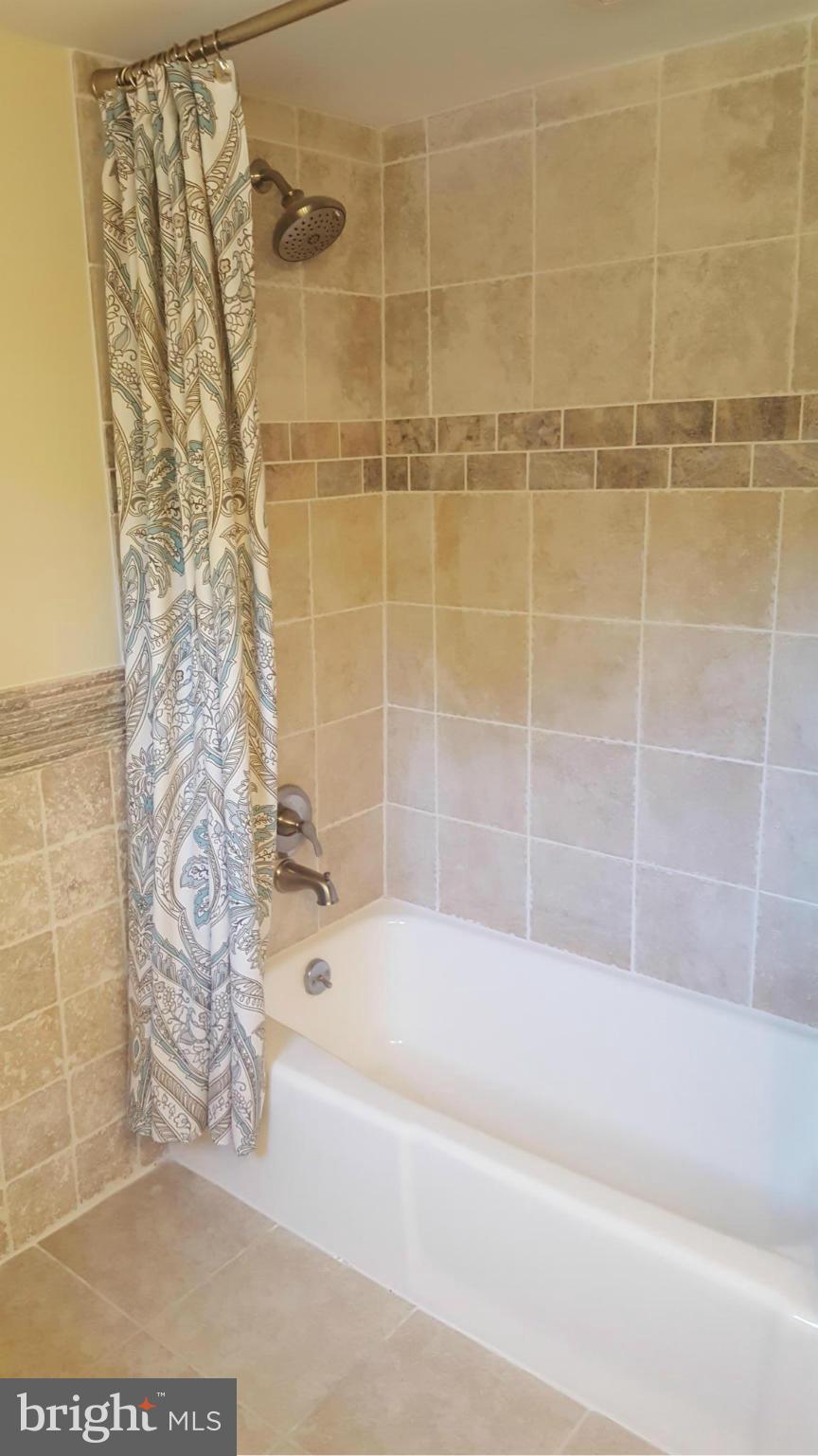 6009 Poplar Road St. Leonard, MD 20685 - Photo 3 of 26 a bathroom with a bathtub and shower