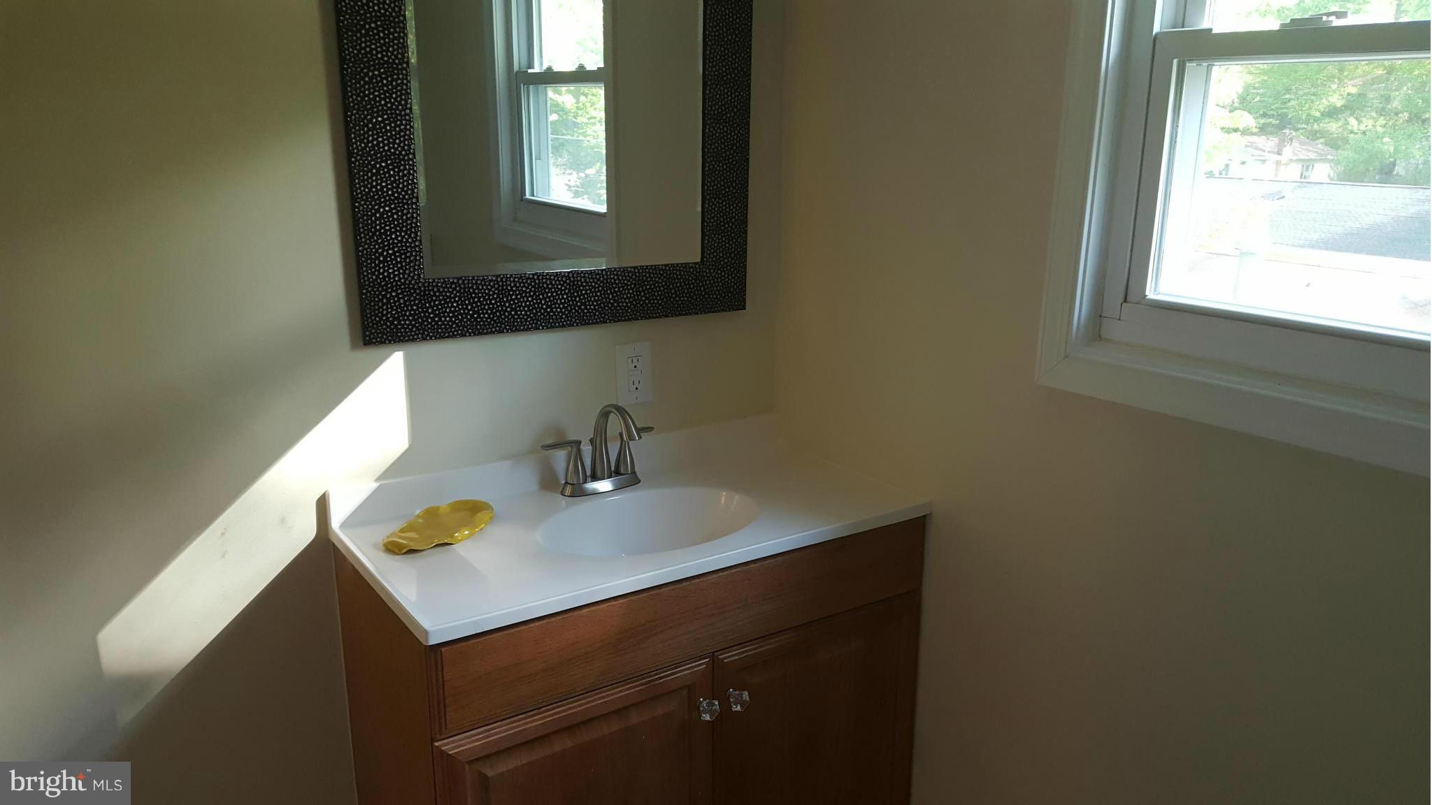 6009 Poplar Road St. Leonard, MD 20685 - Photo 21 of 26 a bathroom with a sink a vanity and a window