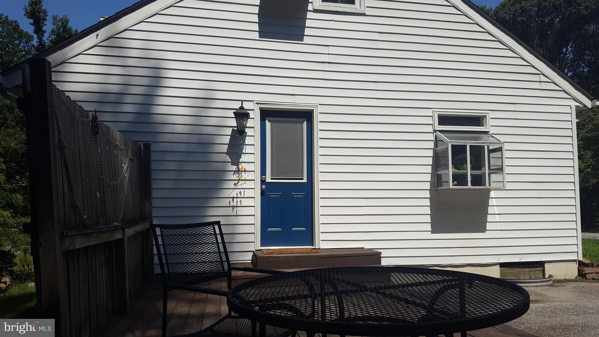 6009 Poplar Road St. Leonard, MD 20685 - Photo 22 of 26 a view of a house with a small deck and a chair