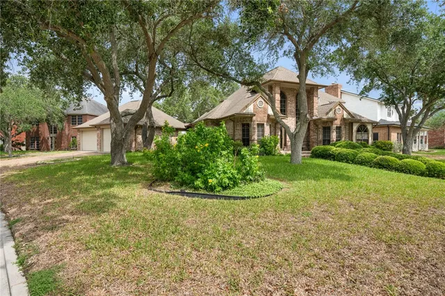 a front view of a house with yard and green space