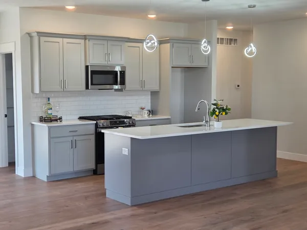 a kitchen with a sink a microwave and cabinets