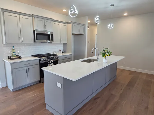 a kitchen with stainless steel appliances granite countertop a stove a sink and a refrigerator