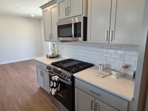 a kitchen with a sink a stove and wooden floor