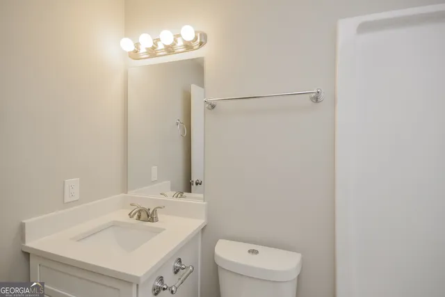 a bathroom with a sink vanity mirror and toilet