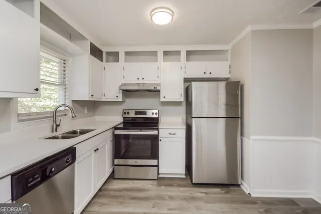 a kitchen with stainless steel appliances a refrigerator sink and cabinets