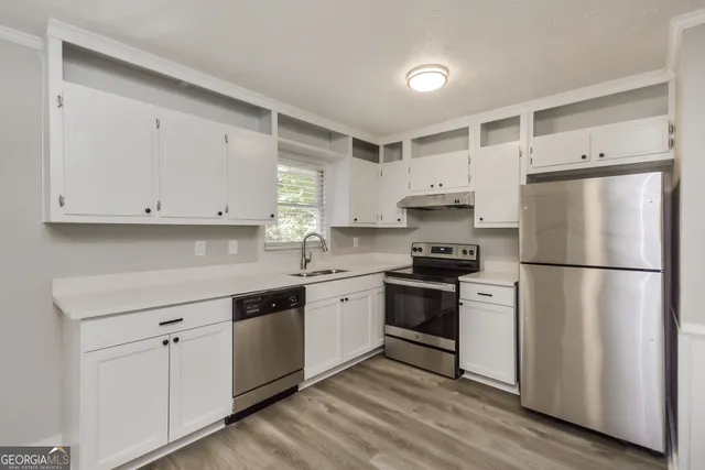 a kitchen with stainless steel appliances white cabinets and a refrigerator