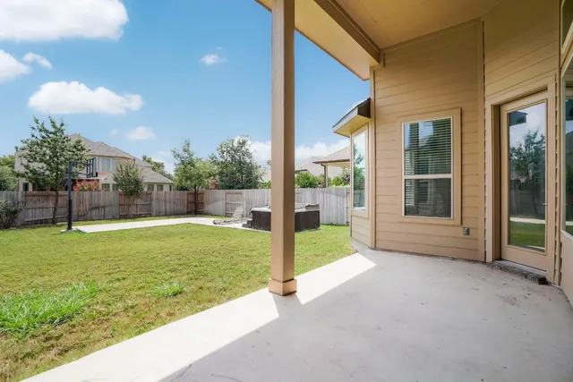 a view of a backyard with a tub and wooden fence