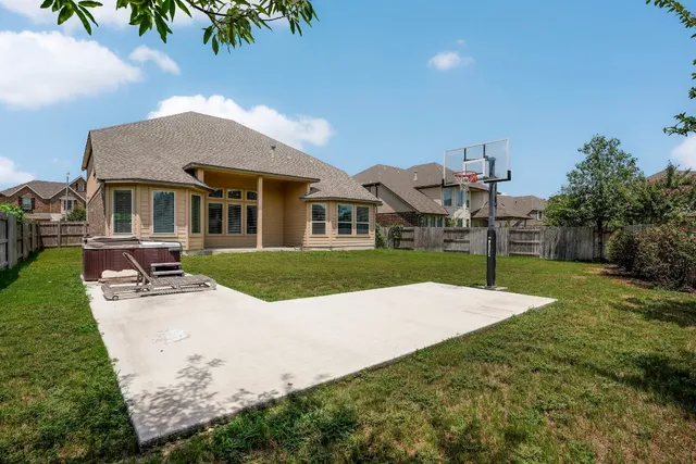 a view of a white house with a yard and sitting area