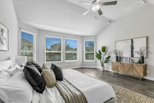 a spacious bedroom with a bed a chandelier and large window