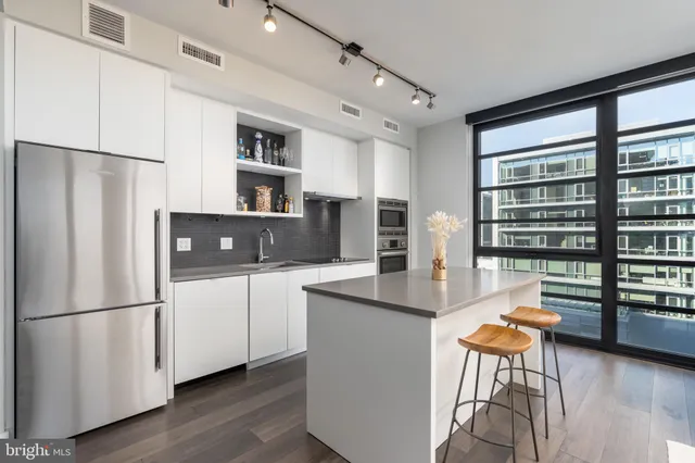 a kitchen with stainless steel appliances granite countertop a refrigerator and a stove top oven
