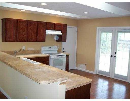 1050 Southwest Fenway Road Port St. Lucie, FL 34953 - Photo 11 of 11 a kitchen with stainless steel appliances granite countertop a sink stove and wooden floor