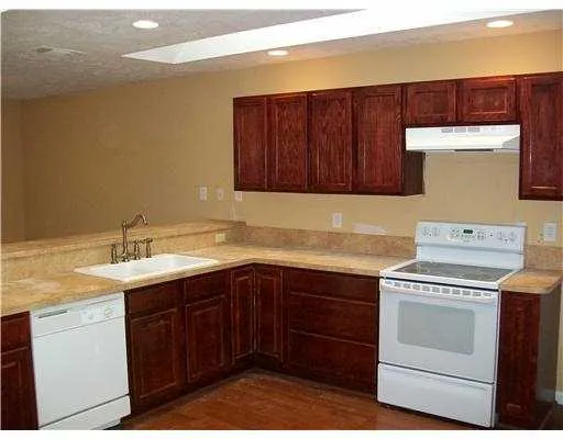 a kitchen with a stove sink and cabinets