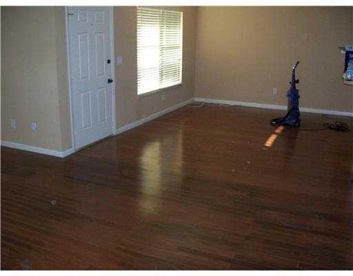 1050 Southwest Fenway Road Port St. Lucie, FL 34953 - Photo 5 of 11 a view of an empty room with wooden floor and a window
