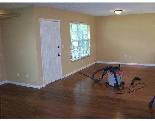 a view of a livingroom with wooden floor and window