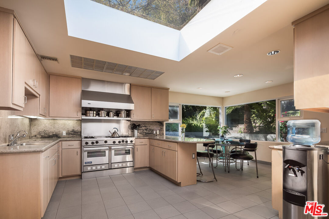 12309 Viewcrest Road Studio City, CA 91604 - Photo 17 of 52 a kitchen with stove cabinets and chairs