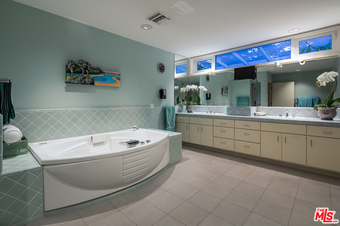 12309 Viewcrest Road Studio City, CA 91604 - Photo 35 of 52 a bathroom with a sink a large mirror and a bathtub