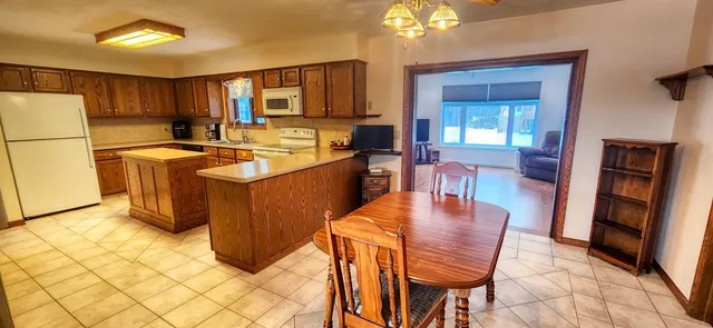 a kitchen with stainless steel appliances granite countertop a refrigerator a stove top oven a sink dishwasher and white cabinets