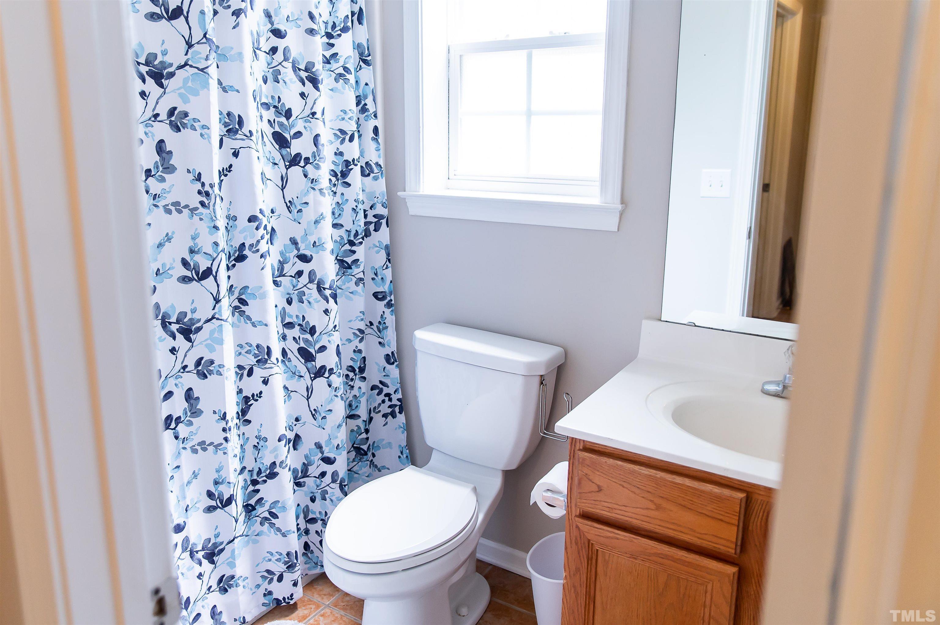 917 Pristine Lane Rolesville, NC 27571 - Photo 12 of 35 a white toilet sitting next to a shower curtain