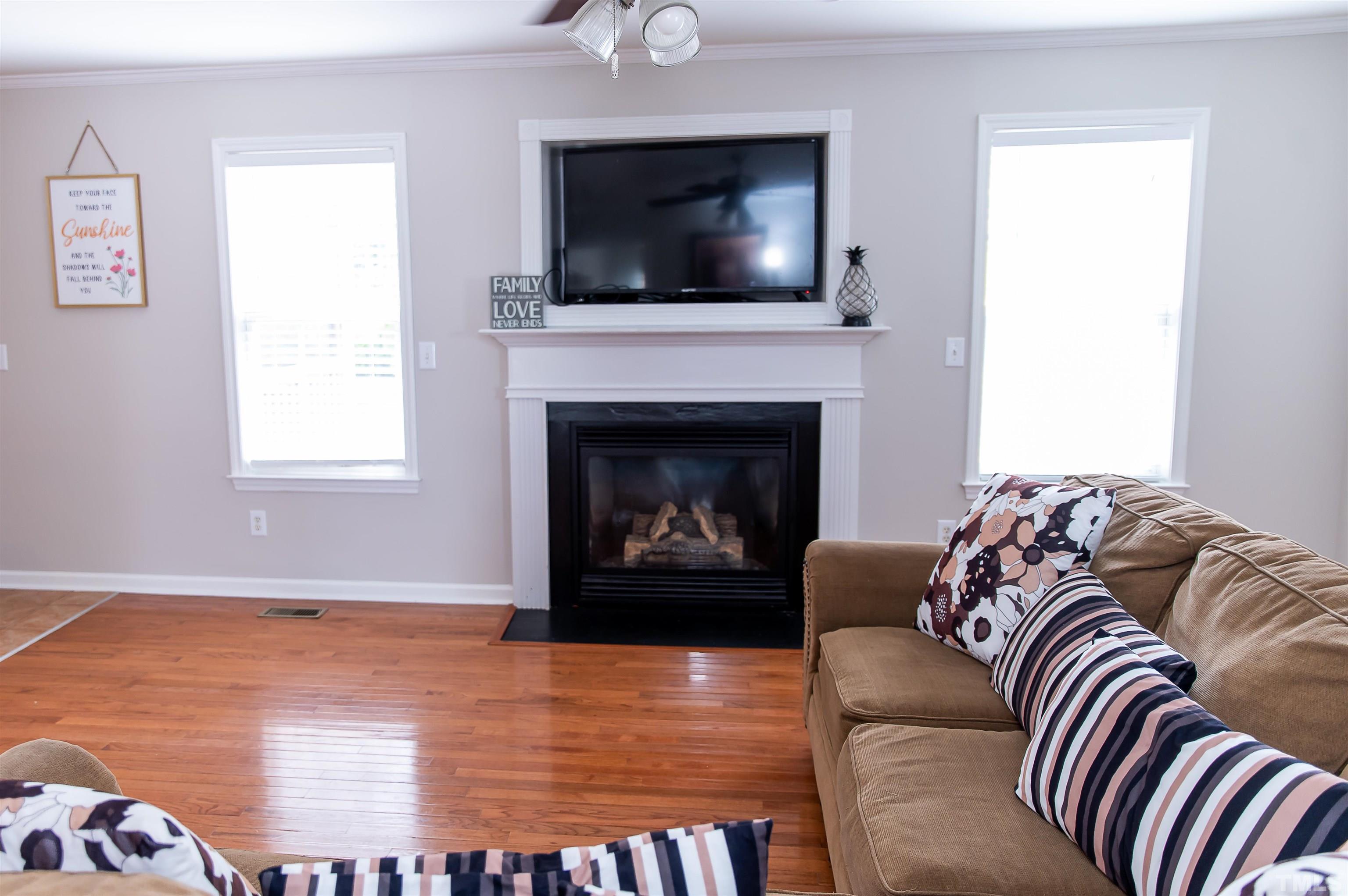 917 Pristine Lane Rolesville, NC 27571 - Photo 18 of 35 a living room with furniture a fireplace and a flat screen tv