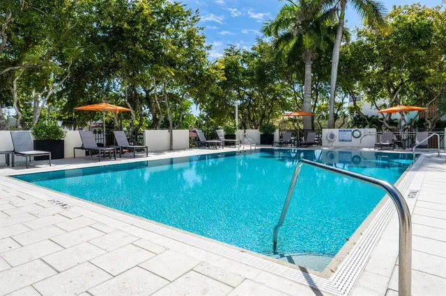 a view of a swimming pool with a patio and a yard