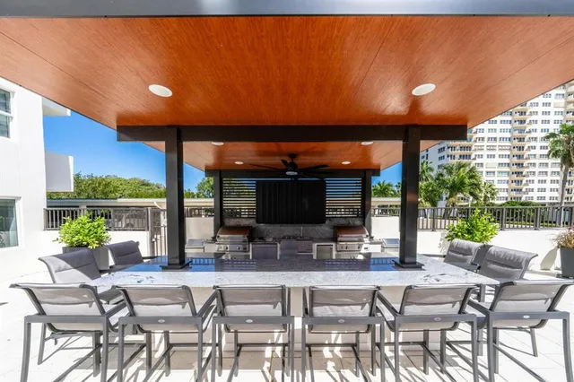 a view of a patio with a dining table and chairs under an umbrella