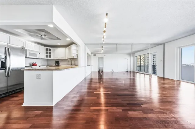 a view of a kitchen with cabinets and wooden floor