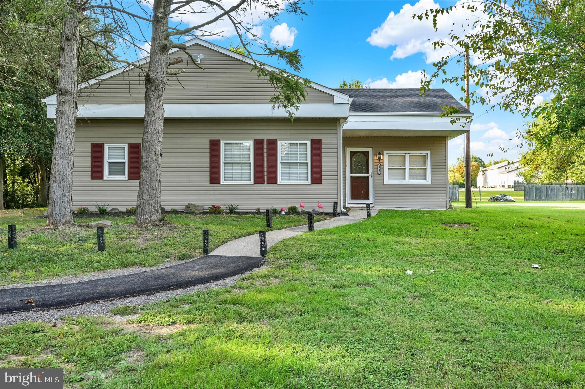 a brick house next to a yard with a large tree