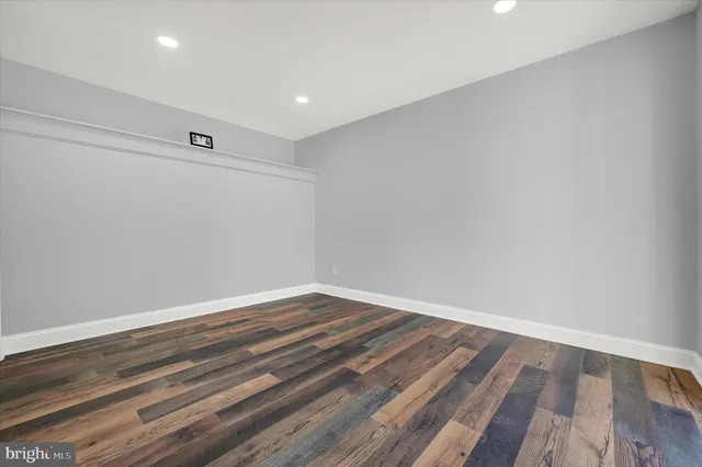 a view of room with wooden floor and white walls