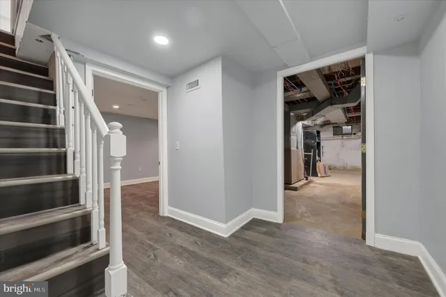 a view of hallway with stairs and wooden floor
