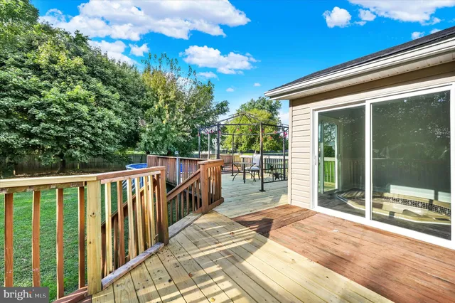 a view of a house with wooden deck next to a lake