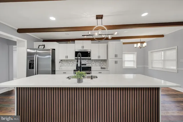 a large kitchen with stainless steel appliances kitchen island granite countertop a sink and cabinets