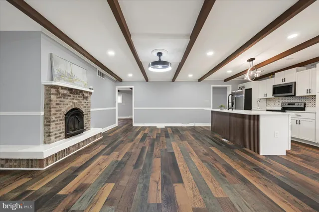 a view of empty room with wooden floor and fireplace