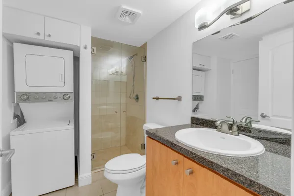 a bathroom with a granite countertop sink toilet and shower