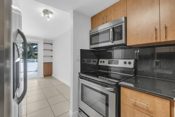 a kitchen with stainless steel appliances granite countertop a stove microwave and refrigerator