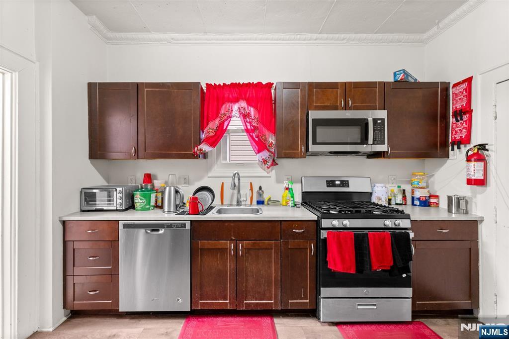 92 South Devine Street Newark, NJ 07106 - Photo 21 of 33 a kitchen with stainless steel appliances granite countertop a stove top oven a sink dishwasher and cabinets with wooden floor