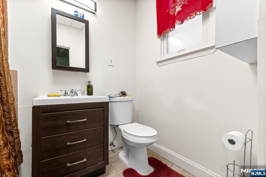 92 South Devine Street Newark, NJ 07106 - Photo 22 of 33 a bathroom with a toilet a sink a vanity and mirror