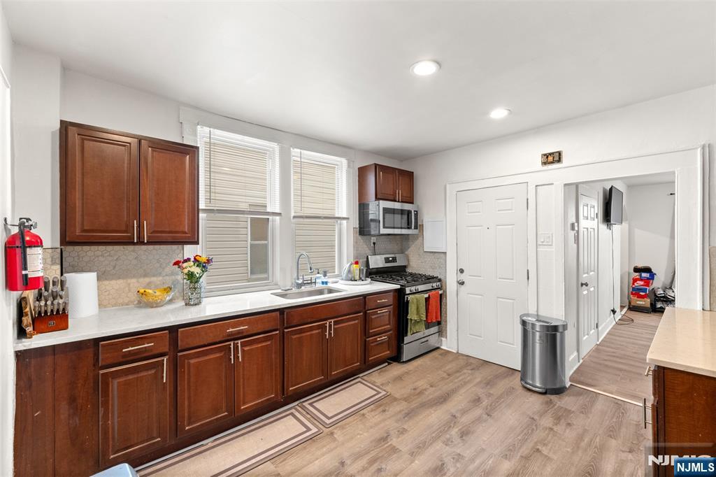 92 South Devine Street Newark, NJ 07106 - Photo 5 of 33 a kitchen with stainless steel appliances sink stove and cabinets