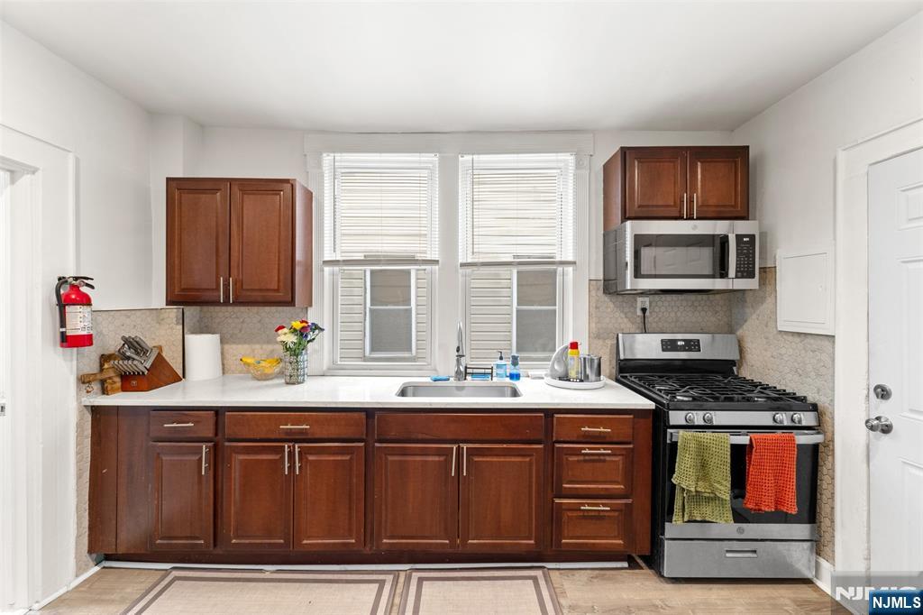 92 South Devine Street Newark, NJ 07106 - Photo 6 of 33 a kitchen with stainless steel appliances granite countertop a sink stove and cabinets