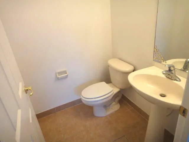 a white toilet sitting next to a bathroom sink