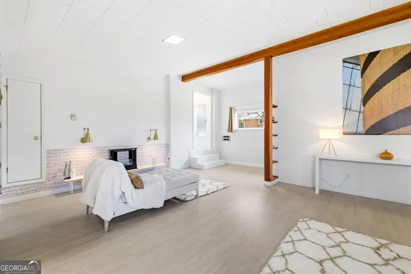 a spacious bedroom with a bed and wooden floor