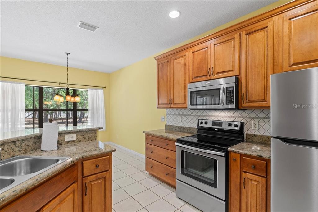 124 Mandarin Lake Road Melrose, FL 32666 - Photo 12 of 46 a kitchen with stainless steel appliances granite countertop a stove a sink and a microwave