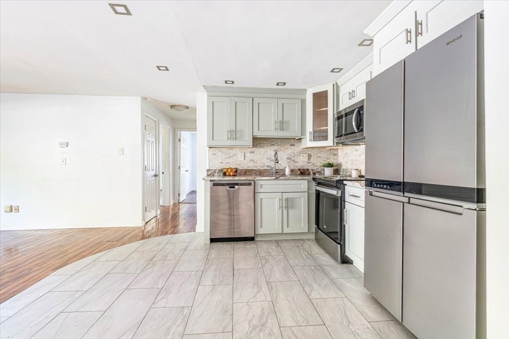 90-92 Sandwich Road, Unit 2D Bourne, MA 02532 - Photo 12 of 29 a kitchen with white cabinets and white appliances
